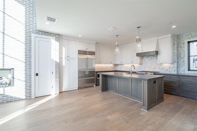 Kitchen featuring custom exhaust hood, pendant lig