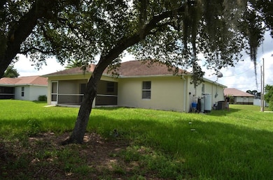 Back of house featuring stucco siding, a lawn, and a sunroom
