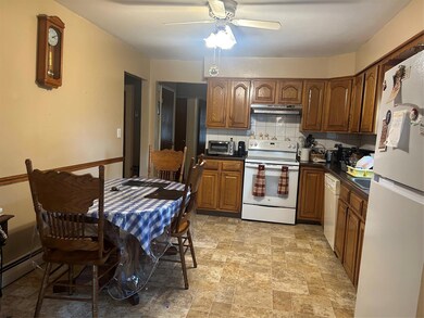 Kitchen featuring range, freestanding refrigerator, exhaust hood, dishwasher, and ceiling fan