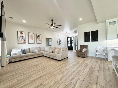 Living room with ceiling fan with notable chandeli
