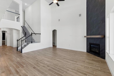 Unfurnished living room with arched walkways, sta