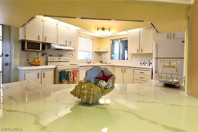 Kitchen with sink, white cabinetry, white applianc
