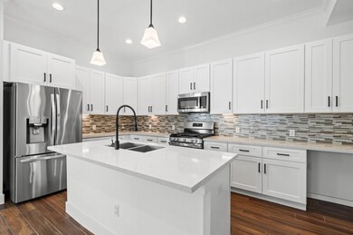 The kitchen boasts modern pendant lighting, sleek