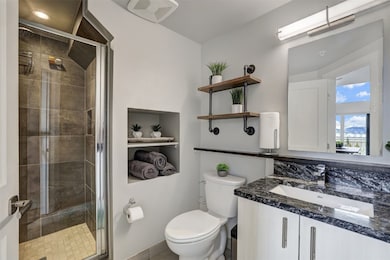 Bathroom featuring a tiled shower stall, toilet, a
