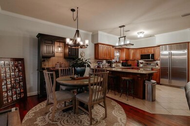 Dining space featuring ornamental molding, light wood-type flooring, and a chandelier