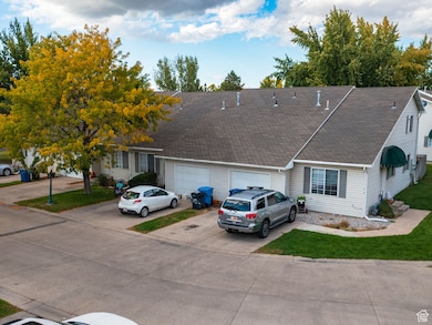 View of front of house with driveway, roof with shingles, and a front lawn