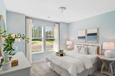 Bedroom featuring light colored carpet and baseboards