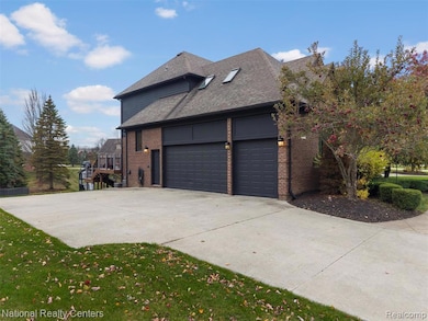 View of side of property with brick siding, concrete driveway, roof with shingles, an attached garage, and a lawn