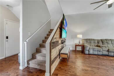 Stairway featuring ceiling fan, wood finished floo