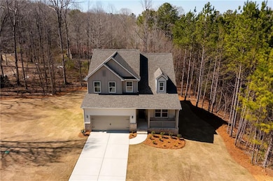 Traditional home with a porch, roof with shingles, concrete driveway, a garage, and board and batten siding