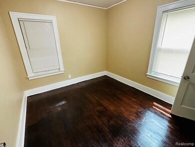 Unfurnished room featuring dark wood finished floors and baseboards
