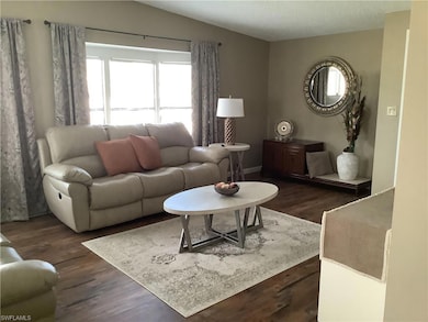 Living room with dark wood-type flooring, vaulted 