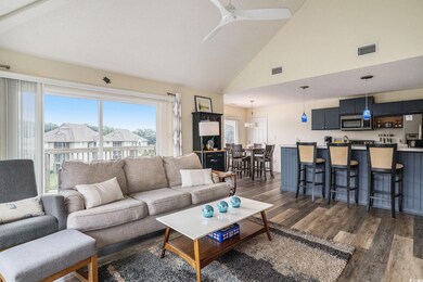 Living area with dark wood-style flooring, high vaulted ceiling, and ceiling fan