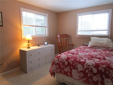This bedroom has large windows and neutral tones. 