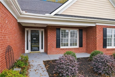 Property entrance featuring brick siding and a shingled roof