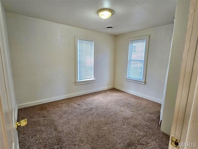 Carpeted empty room featuring baseboards