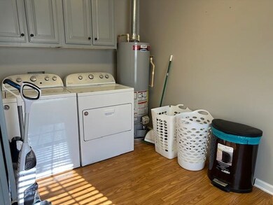 Clothes washing area featuring gas water heater, l