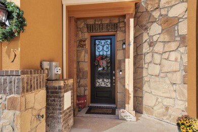 This gorgeous iron, glass and wood door welcomes y