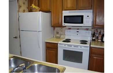 Kitchen with white appliances, a sink, and light 