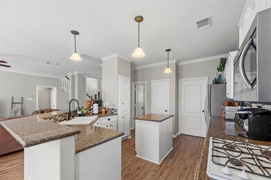 Pendant lighting and a large breakfast bar provides additional seating options.