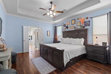 Discover ultimate comfort in this inviting master bedroom. With rich flooring, a sophisticated tray ceiling, and an adjoining private bath, it’s a true sanctuary.