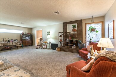 Carpeted living area featuring visible vents, plen