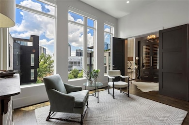Living area with wood finished floors, a chandelier, and a view of city