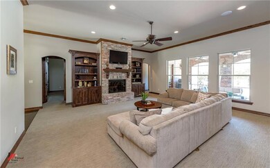 Great room has custom built-ins, brick fireplace, 