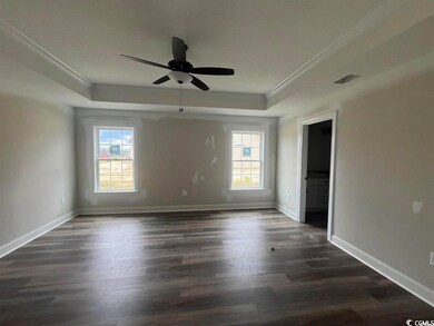 Unfurnished room featuring ceiling fan, dark hardw