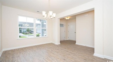 Empty room with a notable chandelier, baseboards, 