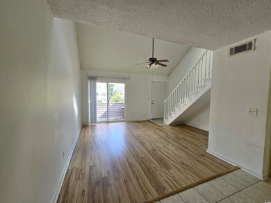 Unfurnished living room with ceiling fan, high vau