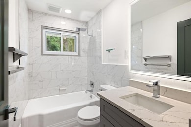 Bathroom featuring toilet, shower / bathtub combin