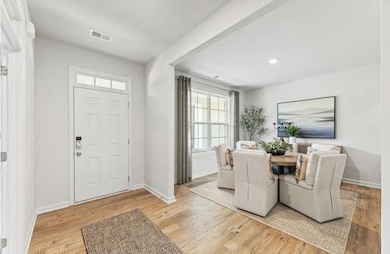 Foyer entrance with light wood finished floors and recessed lighting