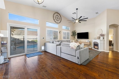 Living room featuring arched walkways, dark wood f