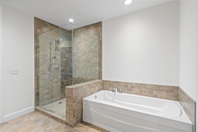 Bathroom with shower with separate bathtub and til