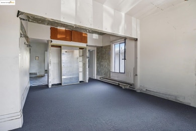 Empty room with dark carpet and baseboard heating