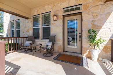 Entrance to property with stone siding and covere