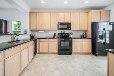 Large, bright kitchen with granite counter tops.