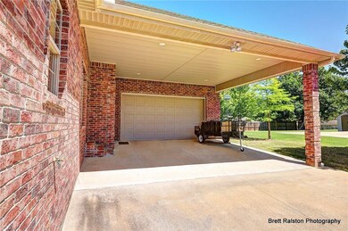 Covered two car carport leading into 2 car garage and workshop.
