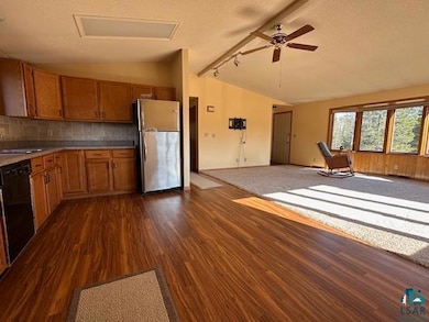 Kitchen featuring lofted ceiling, freestanding ref