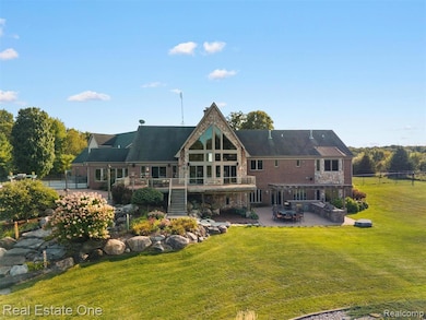Back of property with stone siding, stairs, and a patio