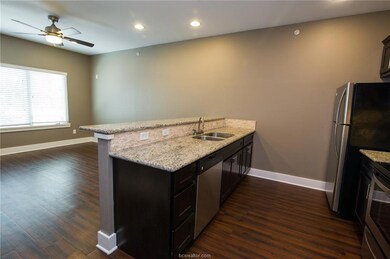 Kitchen with a sink, a peninsula, stainless steel