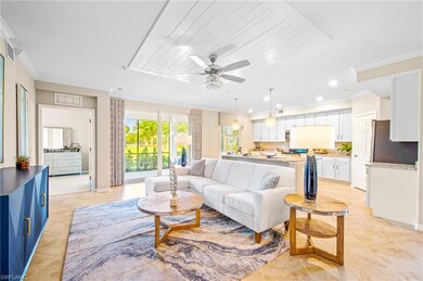 Living room featuring light tile patterned floors, visible vents, ornamental molding, and a ceiling fan