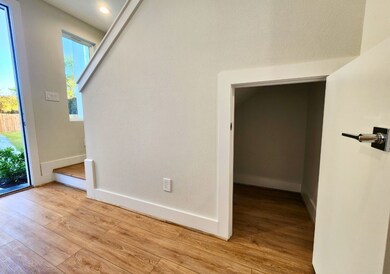 This photo shows a bright entryway with wood floor