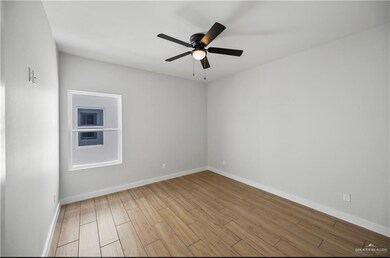 Empty room featuring baseboards, wood finished floors, and ceiling fan