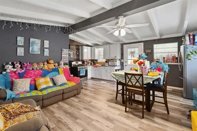 Living room featuring lofted ceiling with beams, light hardwood / wood-style flooring, and ceiling fan