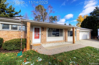 Ranch-style house with brick siding, driveway, a garage, and a patio
