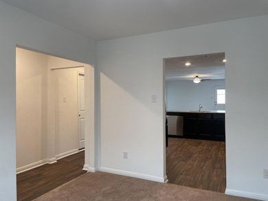 Empty room with a sink, baseboards, dark wood-sty