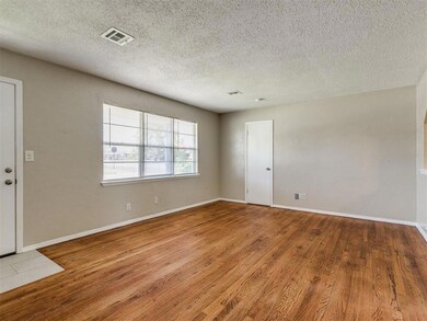 Empty room with wood finished floors and a textured ceiling