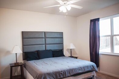 Carpeted bedroom with ceiling fan